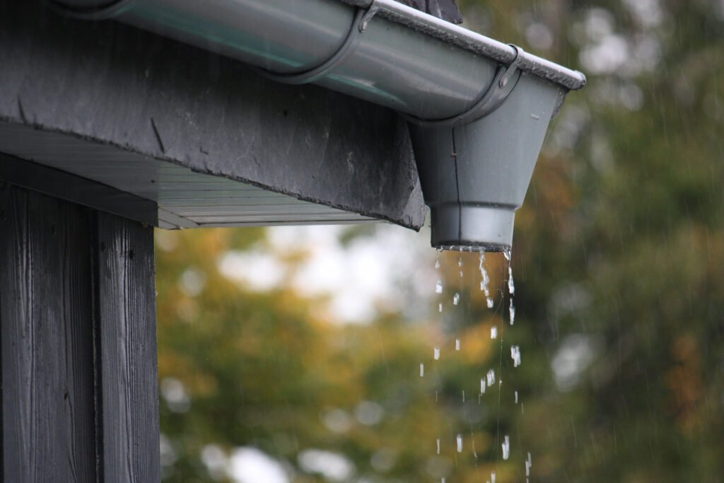 closeup shot water drops falling from rain gutters