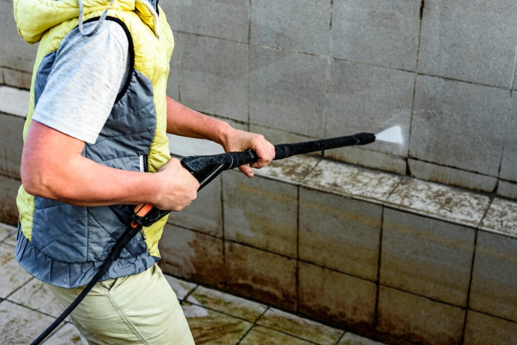 man power washing pool tiles