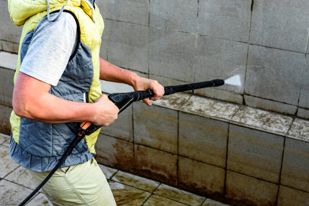man power washing pool tiles